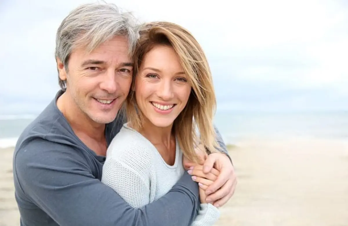 Happy couple smiling together after full arch dental implants at Ardent Smile Clinic